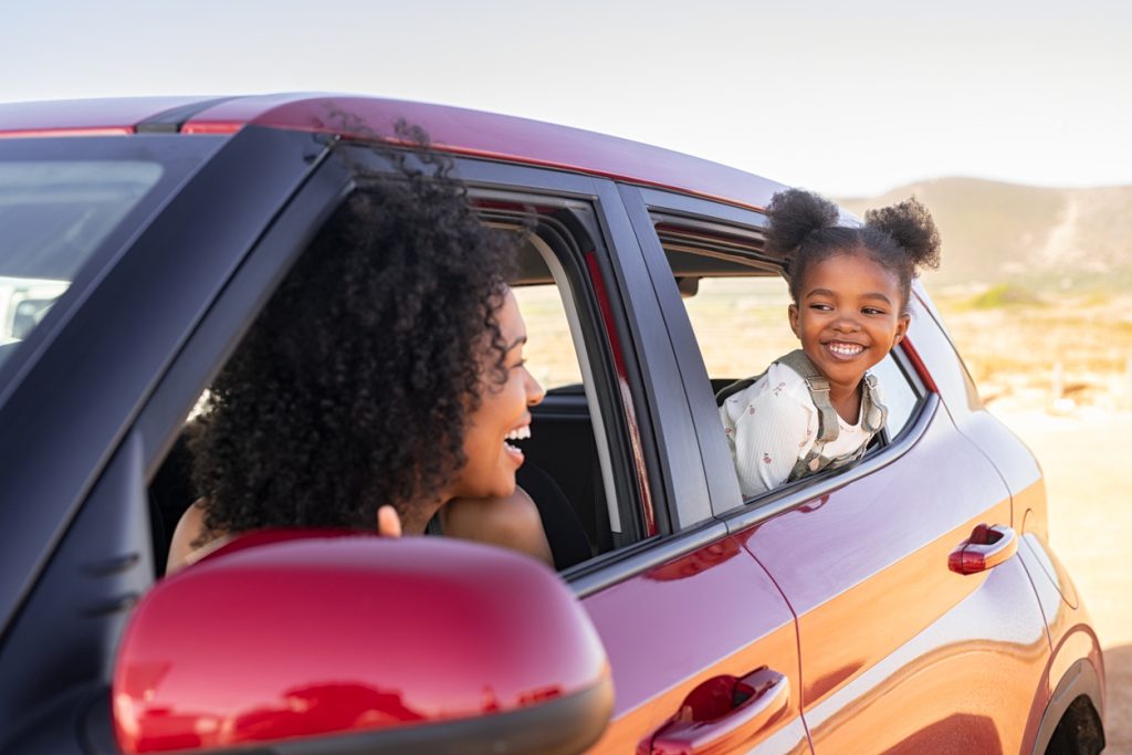 Mother and daughter peeping outside car