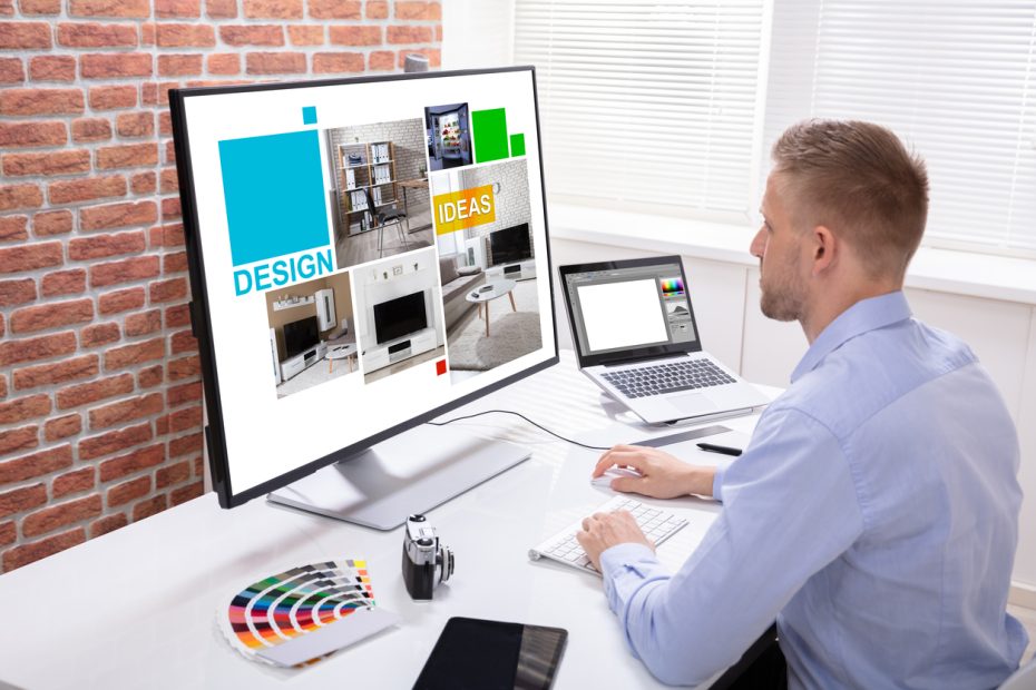 Male Designer Using Graphic Tablet While Working On Computer